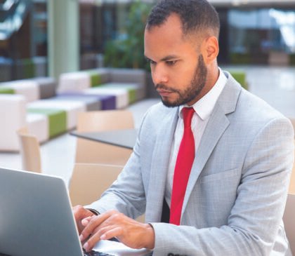 confident-businessman-working-his-laptop