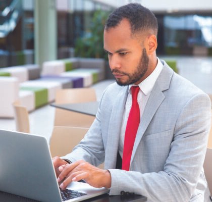 confident-businessman-working-his-laptop