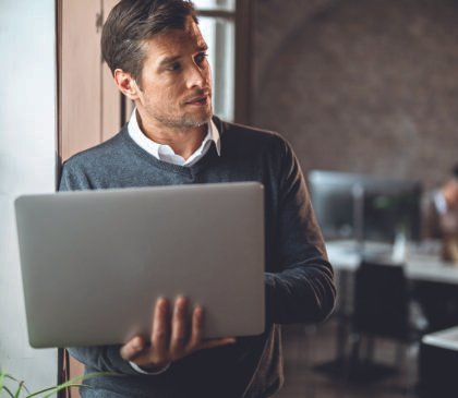 mid-adult-entrepreneur-thinking-something-while-using-computer-by-window-office-001